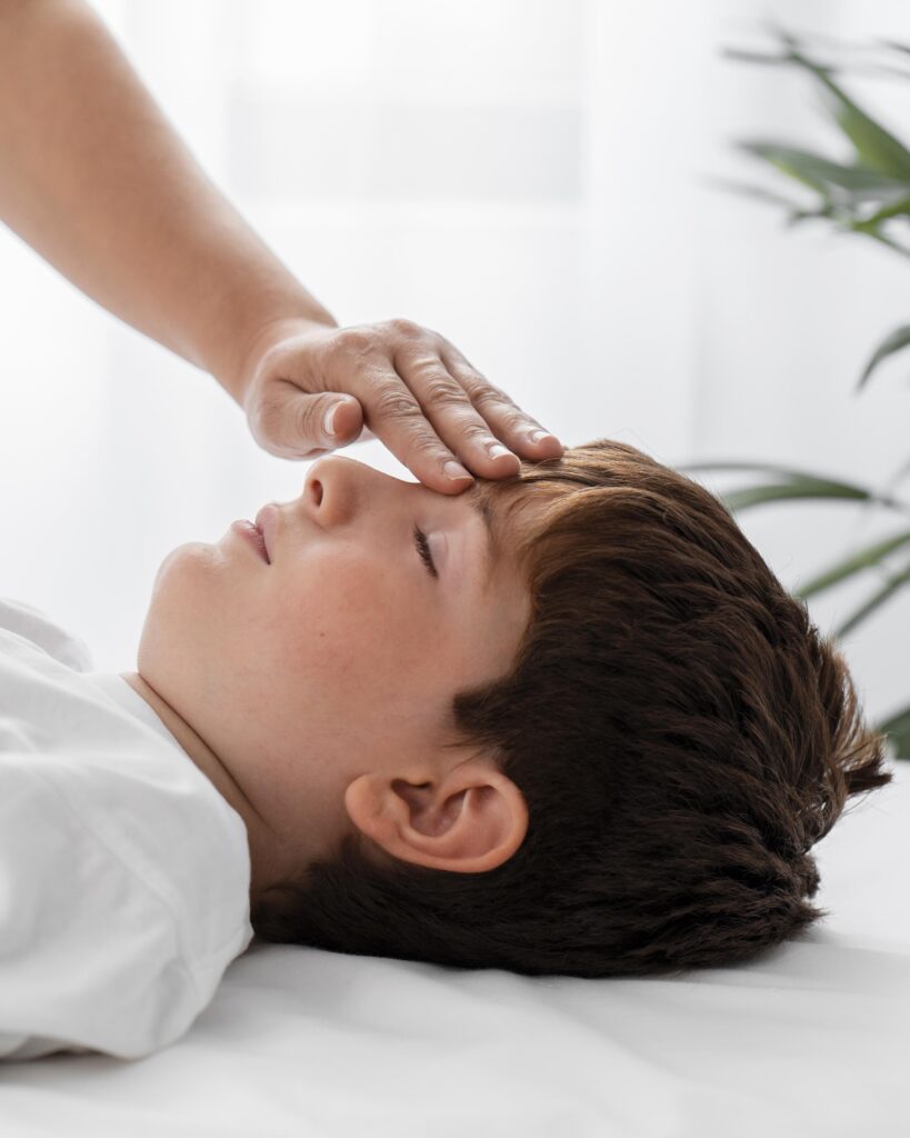 osteopathist treating kid by massaging his head